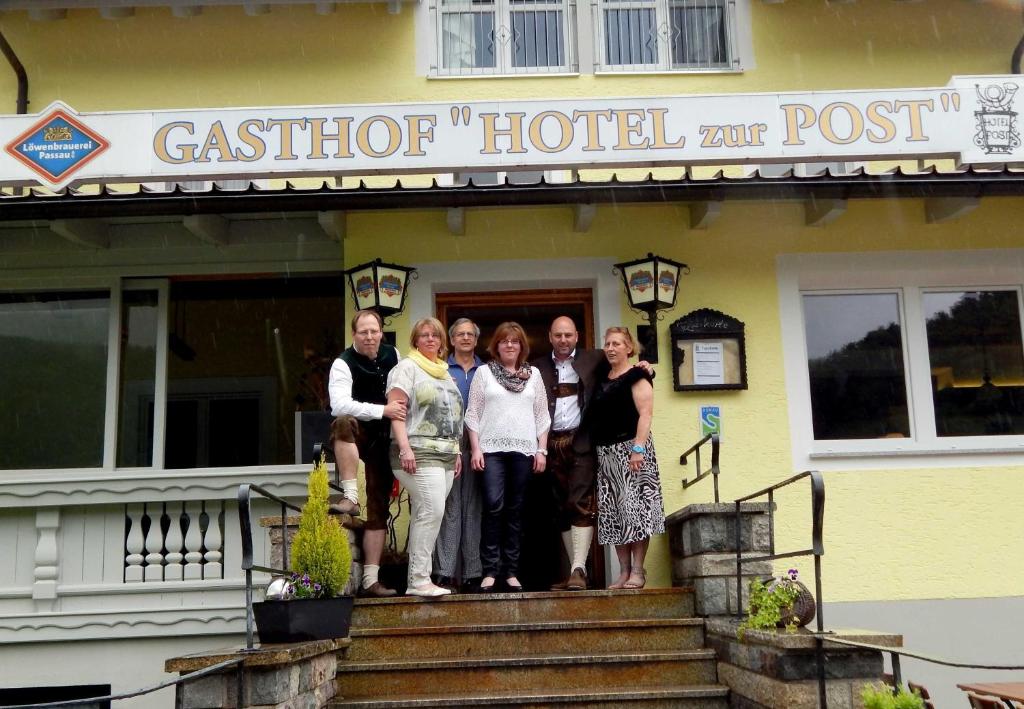 un gruppo di persone che si trovano sui gradini di un posto di un hotel di casota di Ferienwohnungen beim Hotel zur Post, Erlau a Erlau