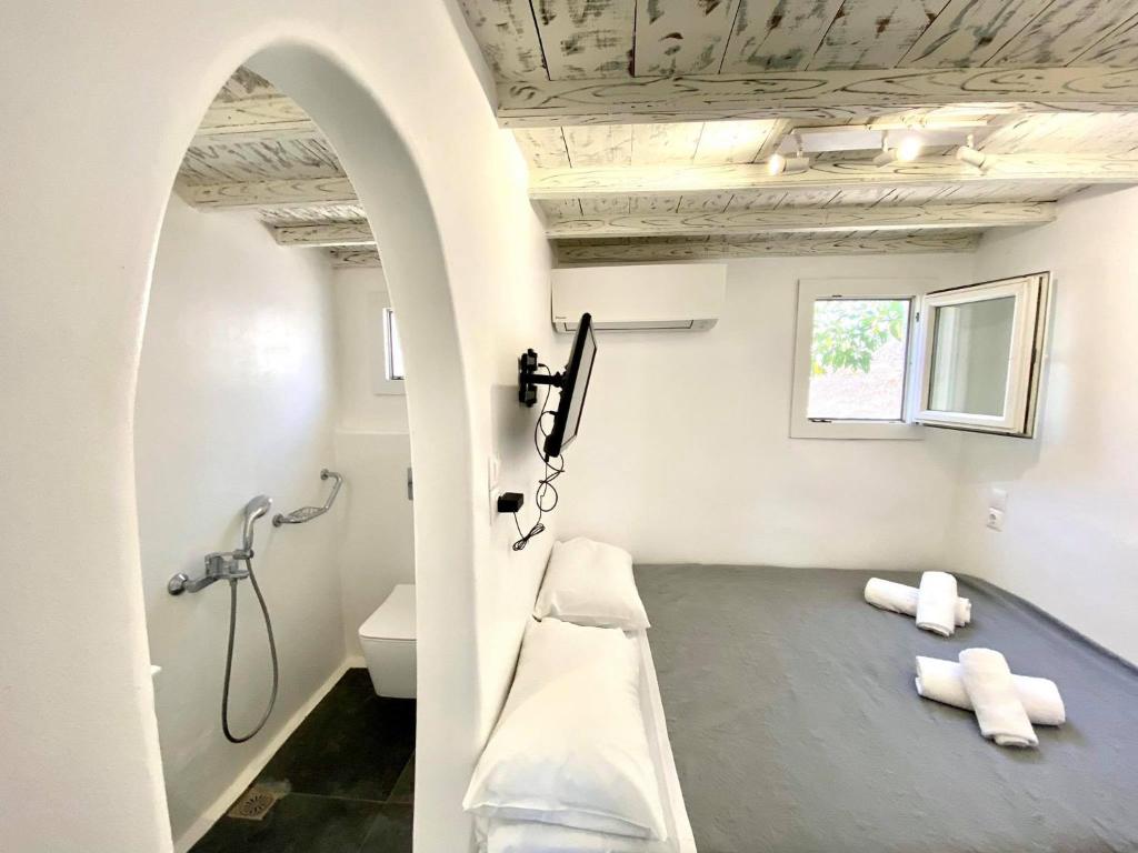 a bathroom with a shower and a bench in a room at MYKONOS VIBES AIRPORT STUDIOS AND APARTMENTS in Aggelika