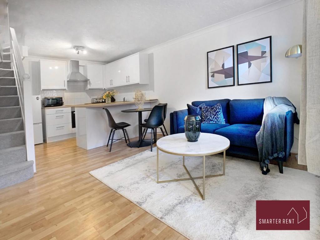 un soggiorno con divano blu e tavolo di Lightwater - One Bedroom House - With Parking a Bagshot