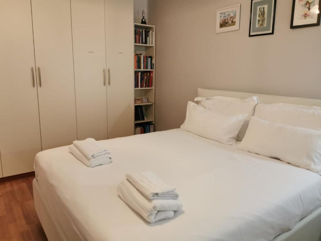 Un dormitorio con una cama blanca con toallas. en PERFECT APARTMENT for centre and Miramare, en Trieste