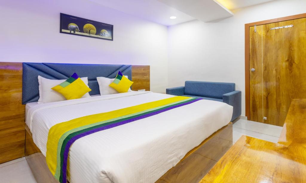 a bedroom with a large bed with a rainbow blanket at Itsy By Treebo - Signature, Nehru Nagar in Ahmedabad