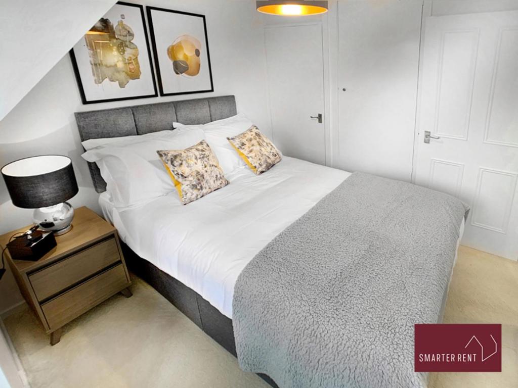 Wokingham - 2 Bedroom Maisonette - With Parking في وكينغهام: غرفة نوم بسرير كبير وموقف ليلي