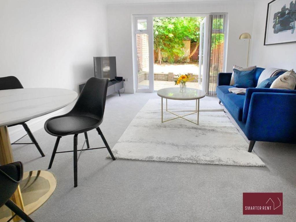 a living room with a blue couch and a table at Twyford - Modern 2 Bedroom House - Garden and Parking in Twyford