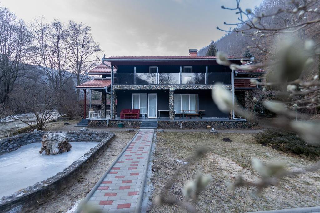 a house with snow on the ground in front of it at Rivendell Chalet in Valea Ierii