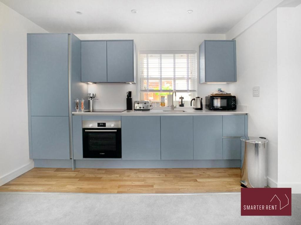 a kitchen with blue cabinets and a stove at Eton, Windsor - 1 Bedroom Ground Floor Apartment - With Parking in Eton