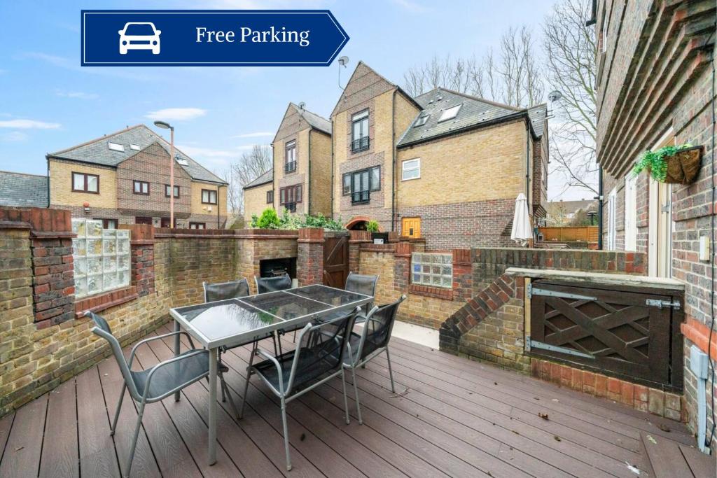 a patio with a table and chairs on a deck at Glamorous 2BR House, Outdoor Space & Free Parking in London