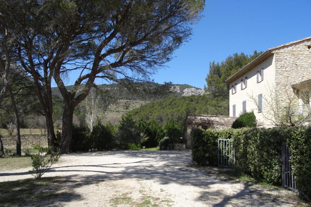 une maison avec un arbre à côté d'une allée dans l'établissement Privatisation Domaine de Cassan, à Lafare