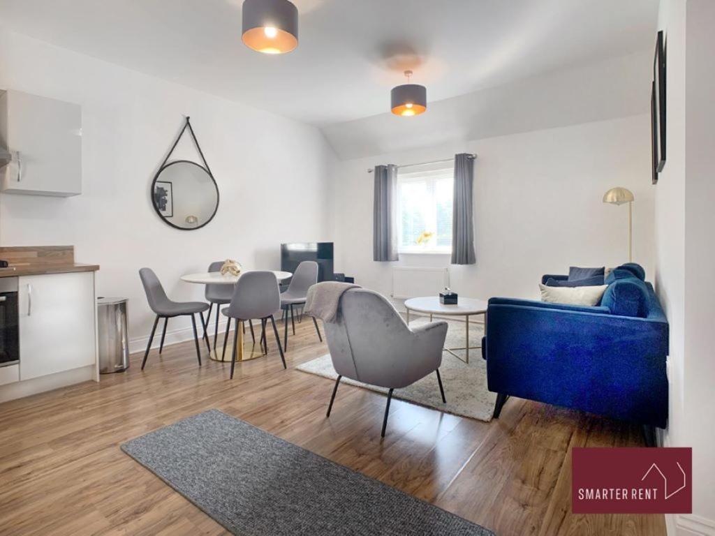 a living room with a blue couch and a table at Jennetts Park, Bracknell - 2 Bedroom Maisonette With Parking in Bracknell