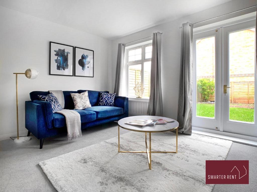un soggiorno con divano blu e tavolo di Bracknell - 2 Bedroom Home With Garden & Parking a Easthampstead