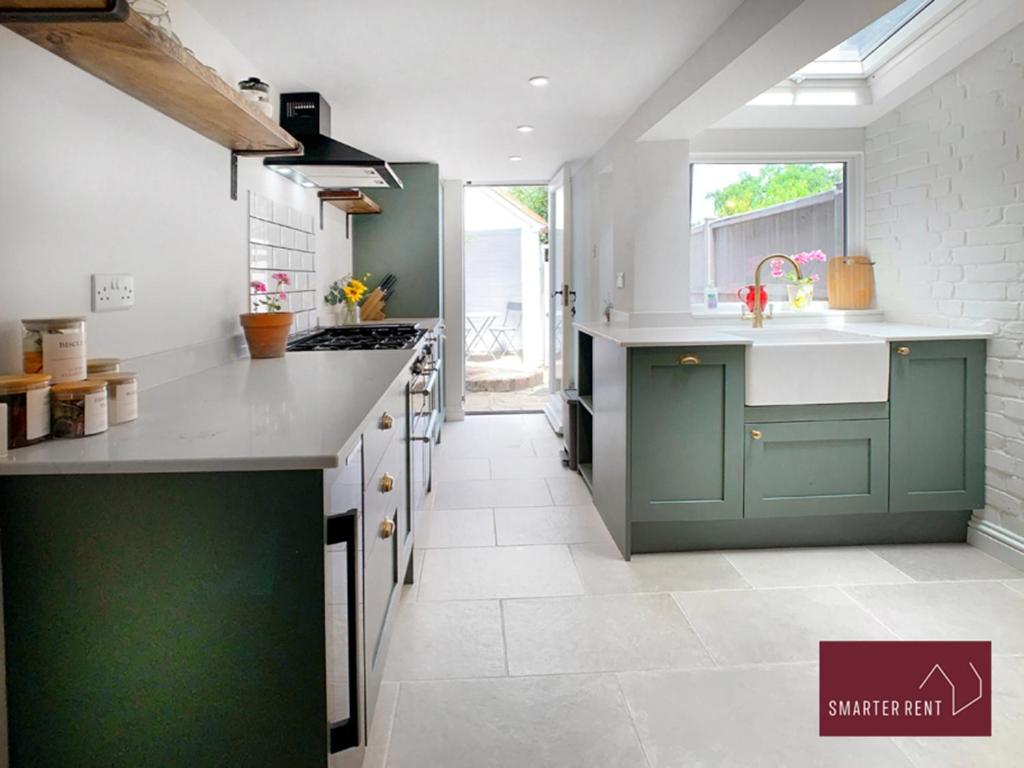 uma cozinha com armários verdes e um balcão branco em Henley-On-Thames - 2 Bedroom Cottage With Permit Parking Close By em Henley on Thames