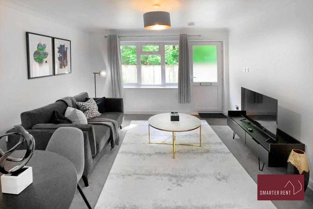 uma sala de estar com um sofá e uma mesa em Farnborough - Lovely 1 Bedroom House em Blackwater
