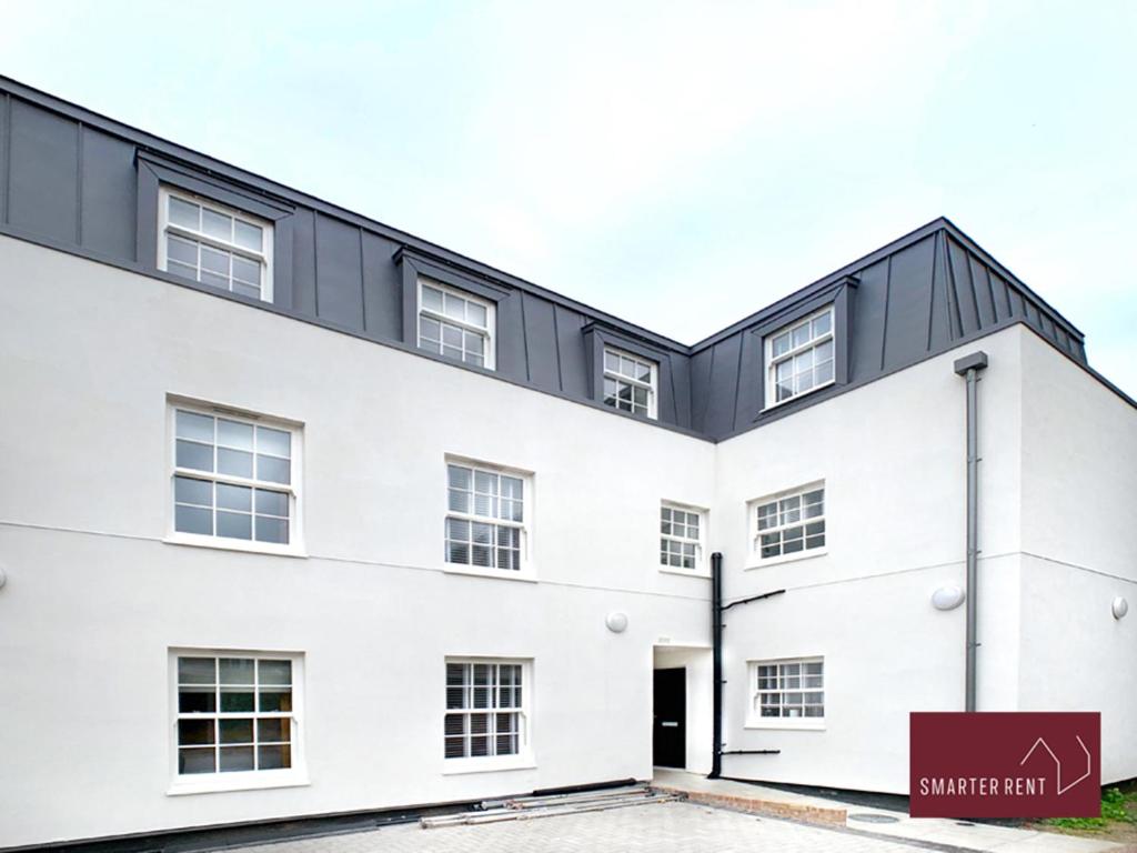 a white building with a black roof at Eton Windsor - 1 Bedroom Flat - With Parking in Eton