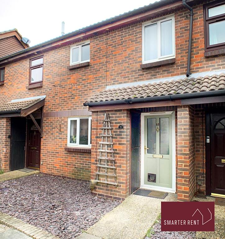 a brick house with a ladder in front of it at Woking - 2 Bedroom House - With Garden in Chobham