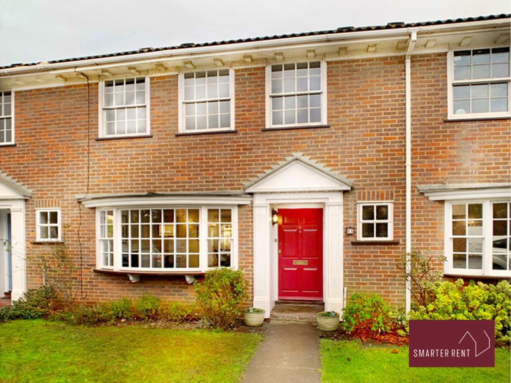 a red brick house with a red door at Maidenhead - Lovely Modern 3 bedroom house in Maidenhead