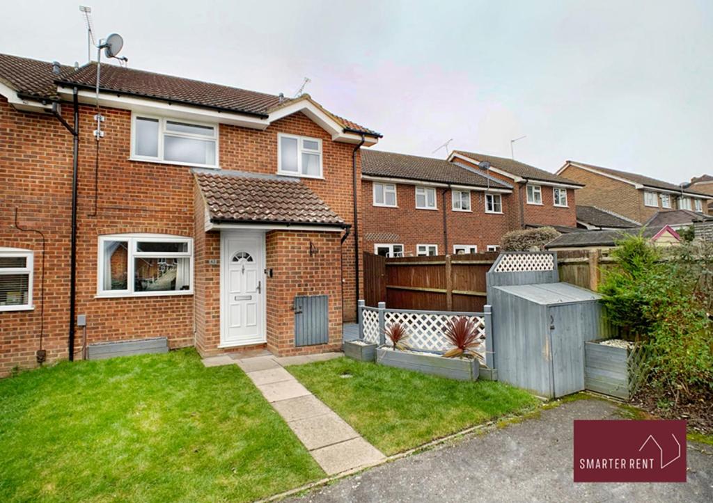 a brick house with a gate and a fence at Yateley - Spacious 2 Bedroom House in Finchampstead