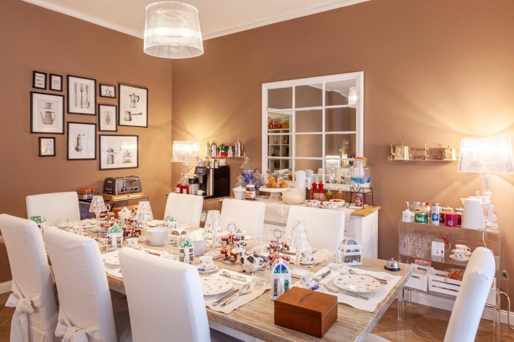 巴勒摩的住宿－Maison de Famille，一间带桌子和白色椅子的用餐室
