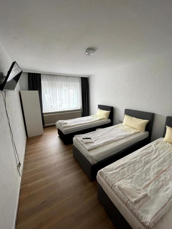 a room with three beds and a window at 3-Z Monteurunterkunft in Einfeld in Neumünster