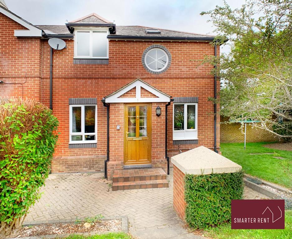 a red brick house with a brown door at Farnborough - Peel Court - 2 Bed Parking & Garden in Cove
