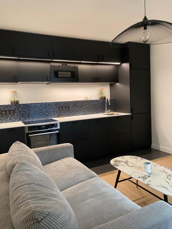 un salon avec un canapé et une table dans l'établissement Cosy appartement 3min de Paris, à Levallois-Perret