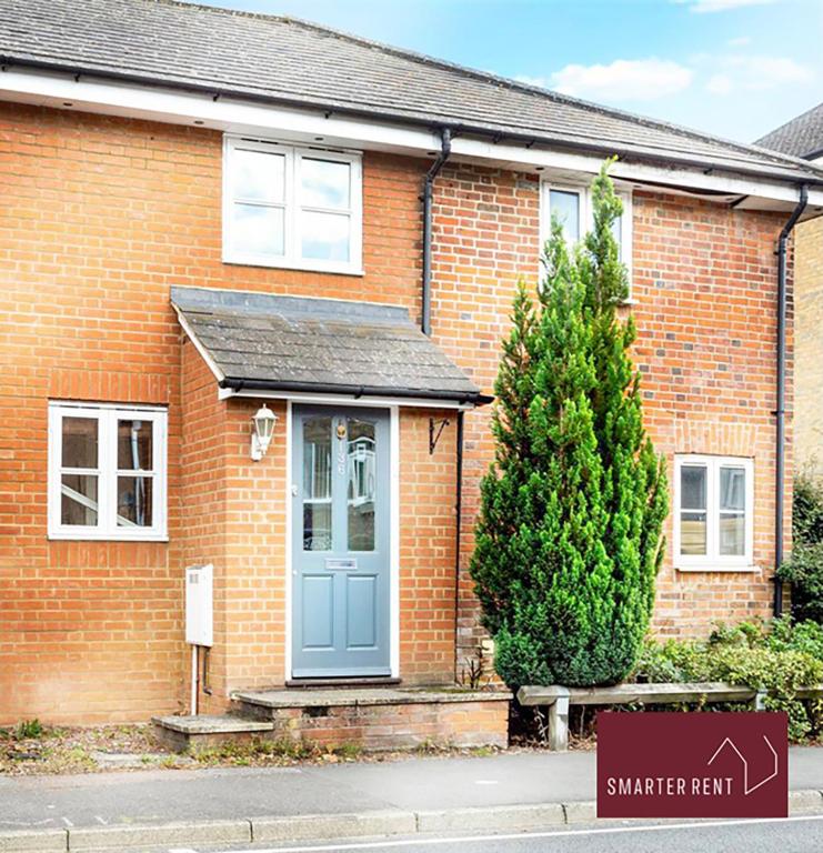 a brick house with a blue door and a tree at Ascot - Parking Garden Pets Welcome in Ascot