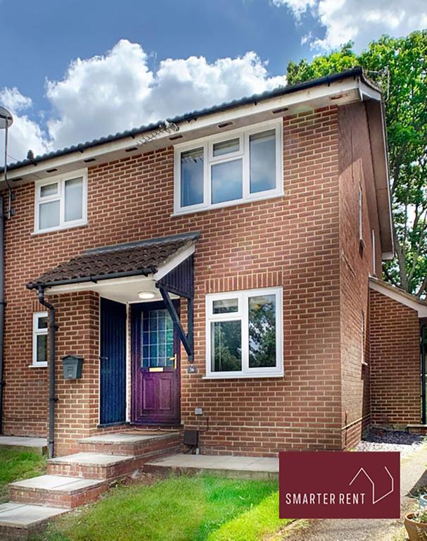 a red brick house with a purple door at Lightwater - 1 Bedroom House - With Parking in Bagshot