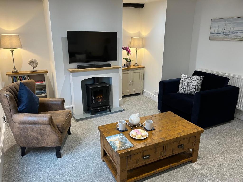 カウズにあるThe Sail Loft, Cowes High Streetの暖炉とテレビのあるリビングルーム
