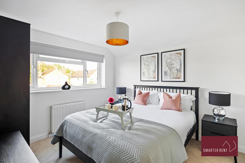 a bedroom with a bed with a table on it at Woking - 4 Bedroom House - With Garden & Driveway in Brookwood