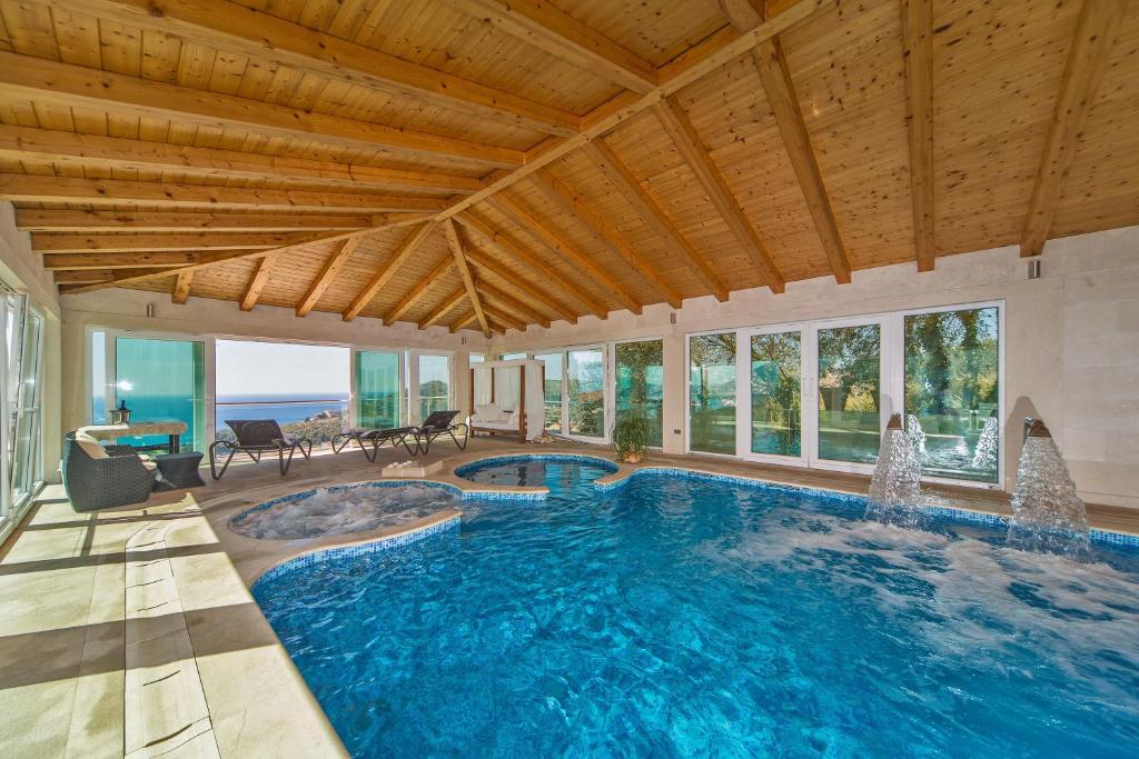 a large swimming pool with a wooden ceiling at Villa Residence Lantoni in Mlini