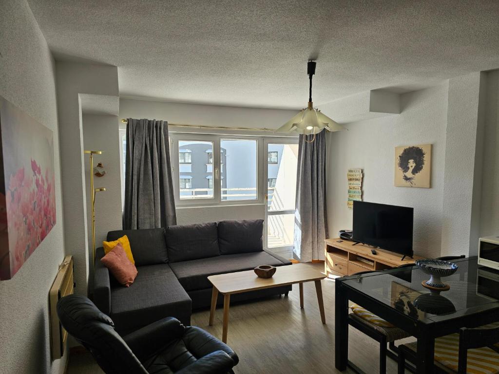 ein Wohnzimmer mit einem Sofa und einem Tisch in der Unterkunft Agradable apartamento familiar in Sierra Nevada