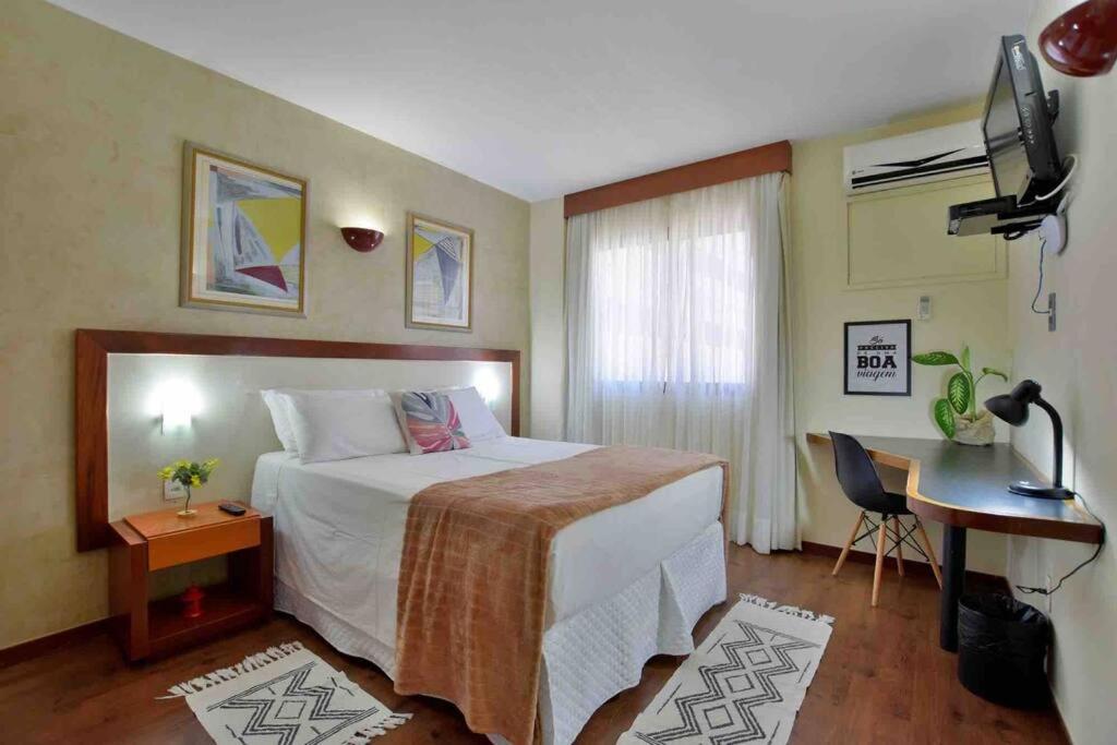 a hotel room with a large bed and a desk at HP02 Flat Particular no Metropolitan Apart-hotel in Brasília