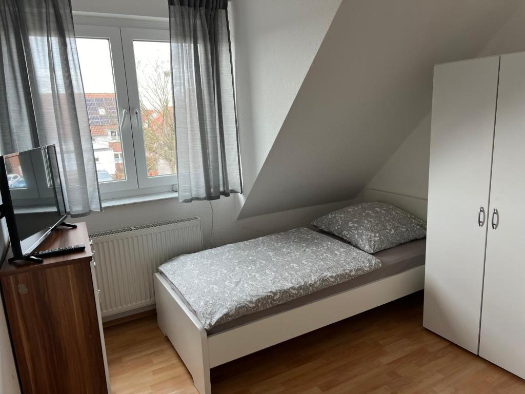 - une petite chambre avec un lit et 2 fenêtres dans l'établissement Messezimmer nahe Flughafen direkte Verbindung Messe, à Langenhagen
