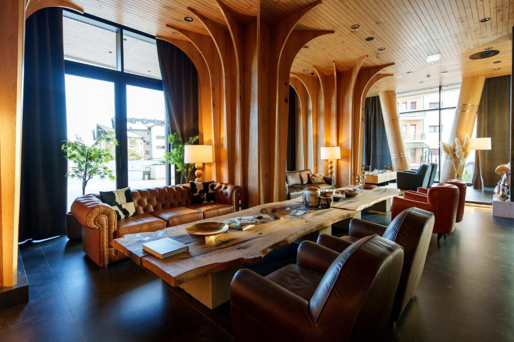 Bor Hotel by Karisma في زلاتيبور: غرفة معيشة كبيرة مع طاولة خشبية كبيرة