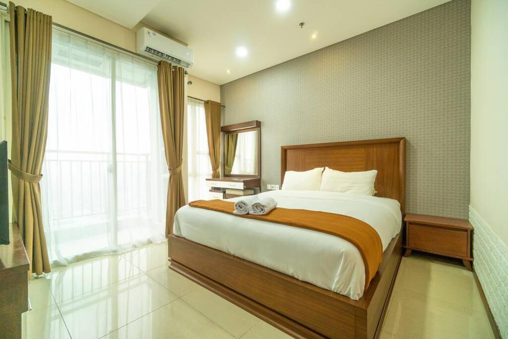 1 dormitorio con cama grande y ventana grande en Charming & lovely 1BR Near GI Mall Thamrin, SCBD, en Yakarta
