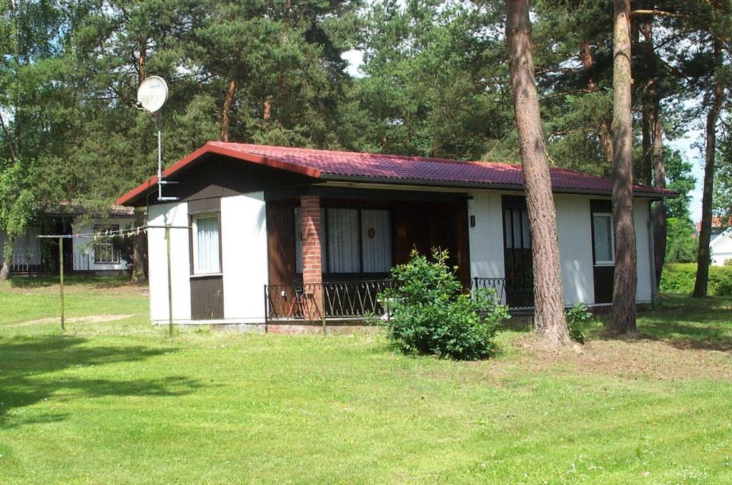 una pequeña casa blanca con techo rojo en 2 Ferienhäuser am Plauer See bis zu 4 Pers en Quetzin