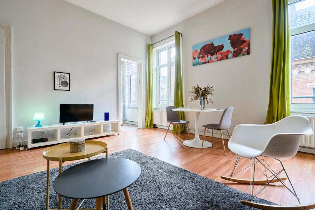 salon z telewizorem, stołem i krzesłami w obiekcie Charmant appartement central w Lille