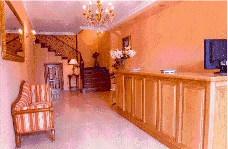 a living room with a chandelier and a staircase at Hotel Las Torres in Arnuero