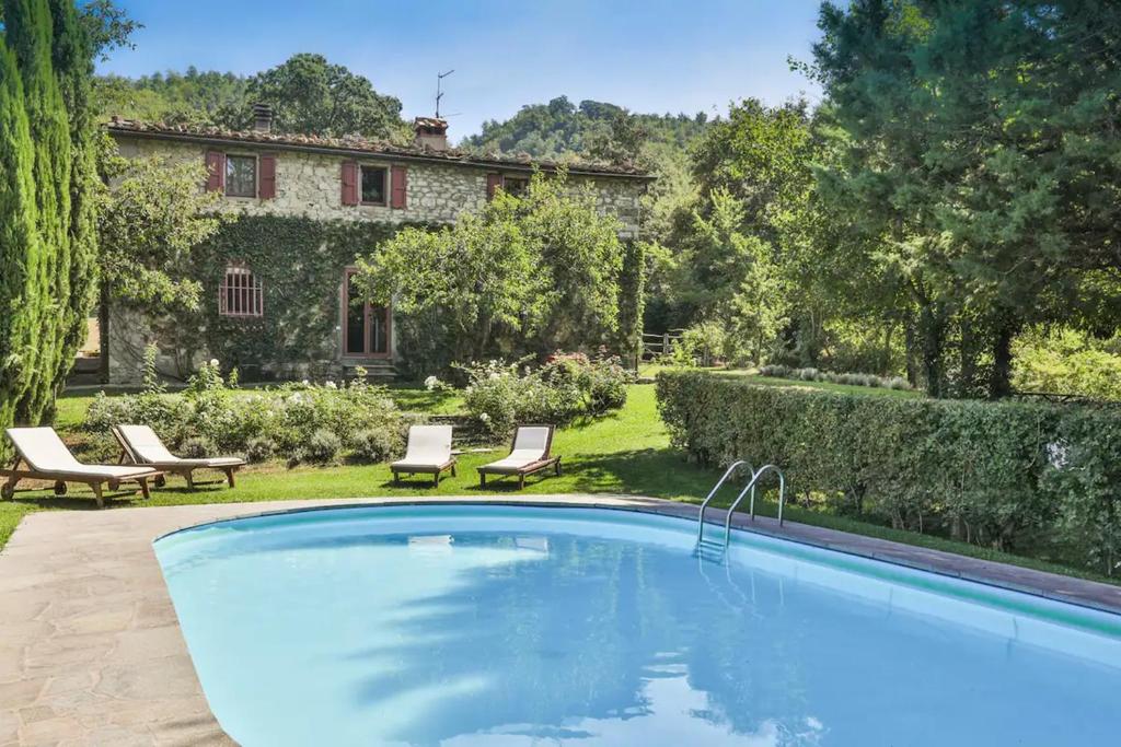een zwembad in een tuin met een huis bij Villa Casanova in Cerbaiolo