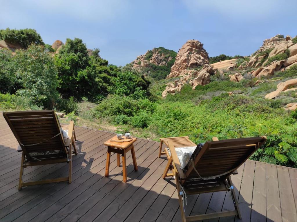 two chairs and a table on a wooden deck at Casa Adriana - Costa Paradiso in Costa Paradiso