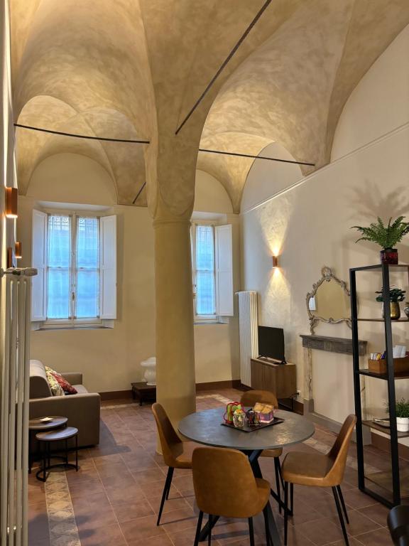 uma sala de estar com mesa e cadeiras em Appartamento L'antica colonna, in centro storico em Parma