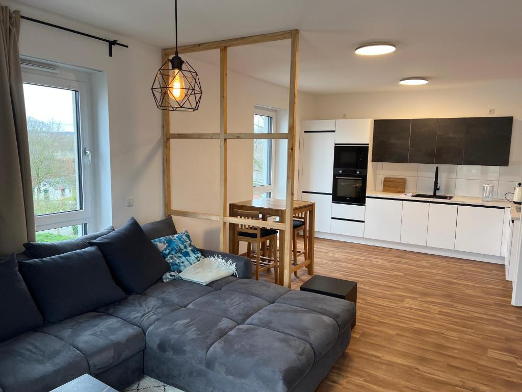 ein Wohnzimmer mit einem Sofa und einer Küche in der Unterkunft Wohnung Nähe Flughafen und Messe in Düsseldorf