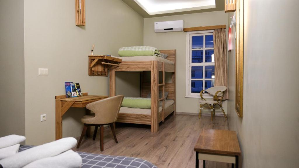イスタンブールにあるセカンド ホーム ホステルの二段ベッドとデスクが備わる小さな客室です。