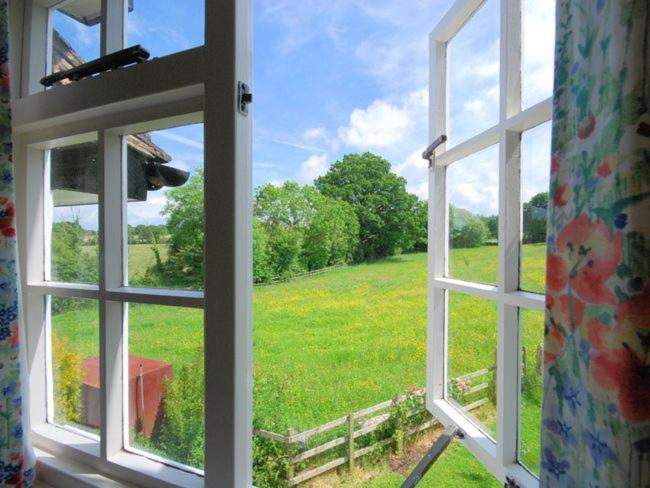 an open window looking out at a field of grass at 2 Bed in Aylesbeare THEDA in Aylesbeare