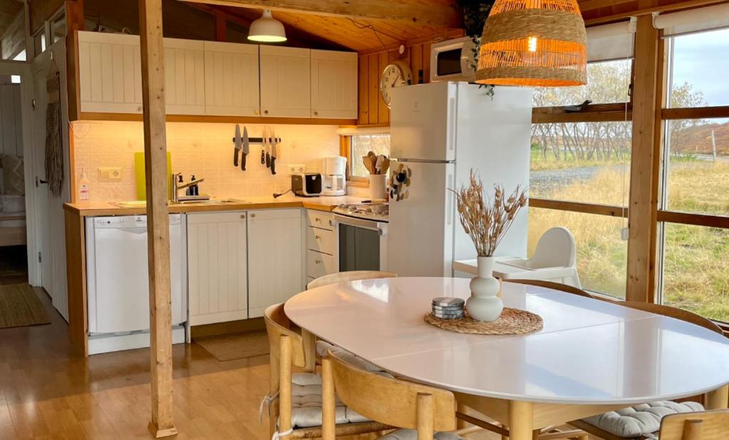 een keuken en eetkamer met een tafel en stoelen bij Hestaland Horse Farm Cottage in Borgarnes