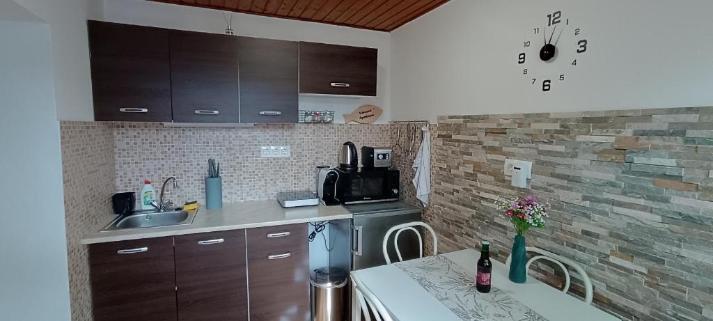 eine Küche mit einer Spüle und einer Arbeitsplatte in der Unterkunft Kis kuckó in Tapolca