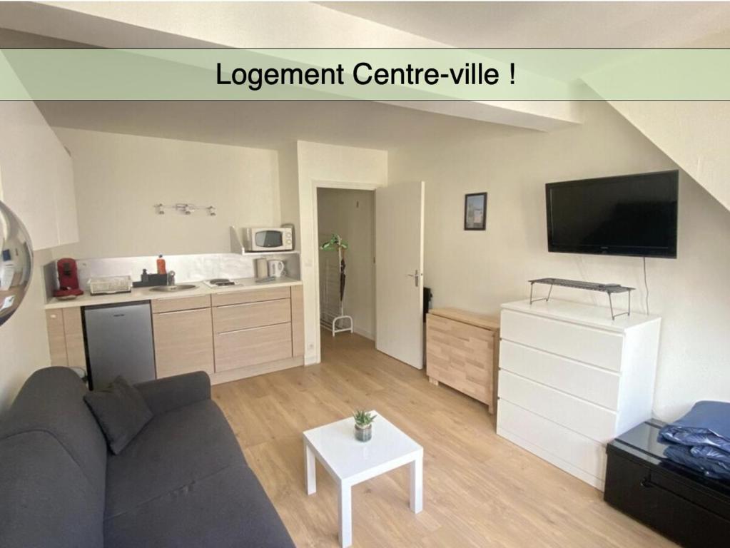 a living room with a couch and a kitchen at Les jardins du gros Horloge, studio in Rouen