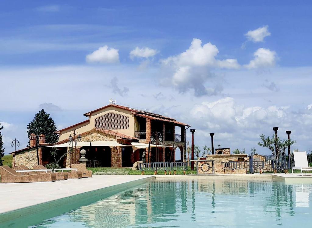 une maison avec une piscine en face d'un bâtiment dans l'établissement Villa Tosca - Volterra, Tuscany, à Montelopio