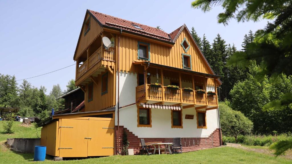 uma casa de madeira com uma varanda ao lado em Haus Heimburg em Rötenbach