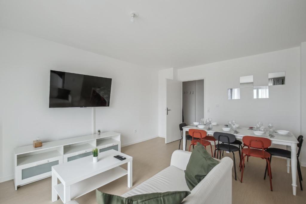 een witte woonkamer met een tafel en stoelen bij Chic and spacious apart with parking in Cergy