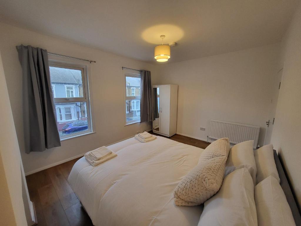 a bedroom with a large white bed and a window at Central 5BR Retreat - Walk to Tube, Explore London in London