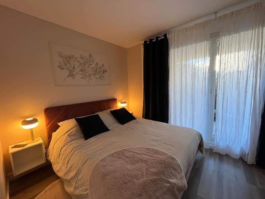 a bedroom with a large bed and a window at Hana Home Guyancourt 4 personnes résidence calme business&family in Guyancourt